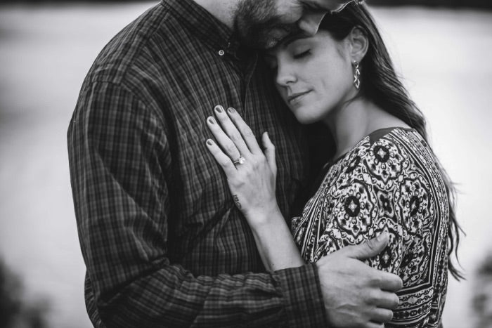 couple embracing while wearing custom engagement rings