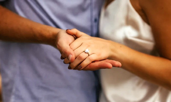 couple holding hands with custom engagement ring