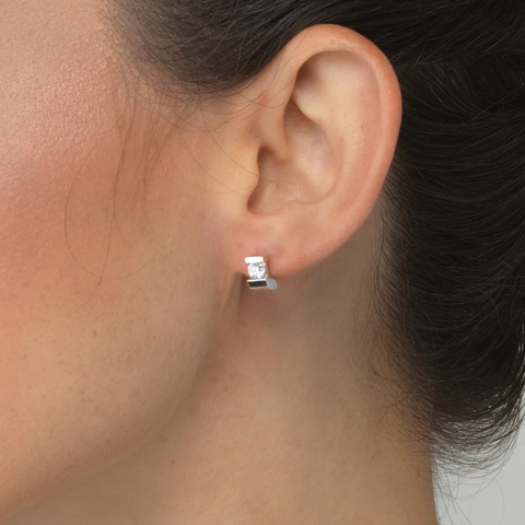 closeup of a woman's earlobe showcasing a diamond stud earring